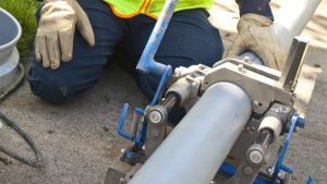 Close up shot of a worker holding a pipeline at a place