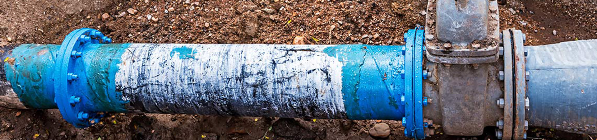 Closeup shot of the blue color pipe in the sand