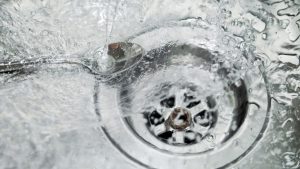 Closeup shot of water, steel spoon and strainer