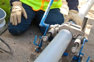 A man holding a large gray color pipe